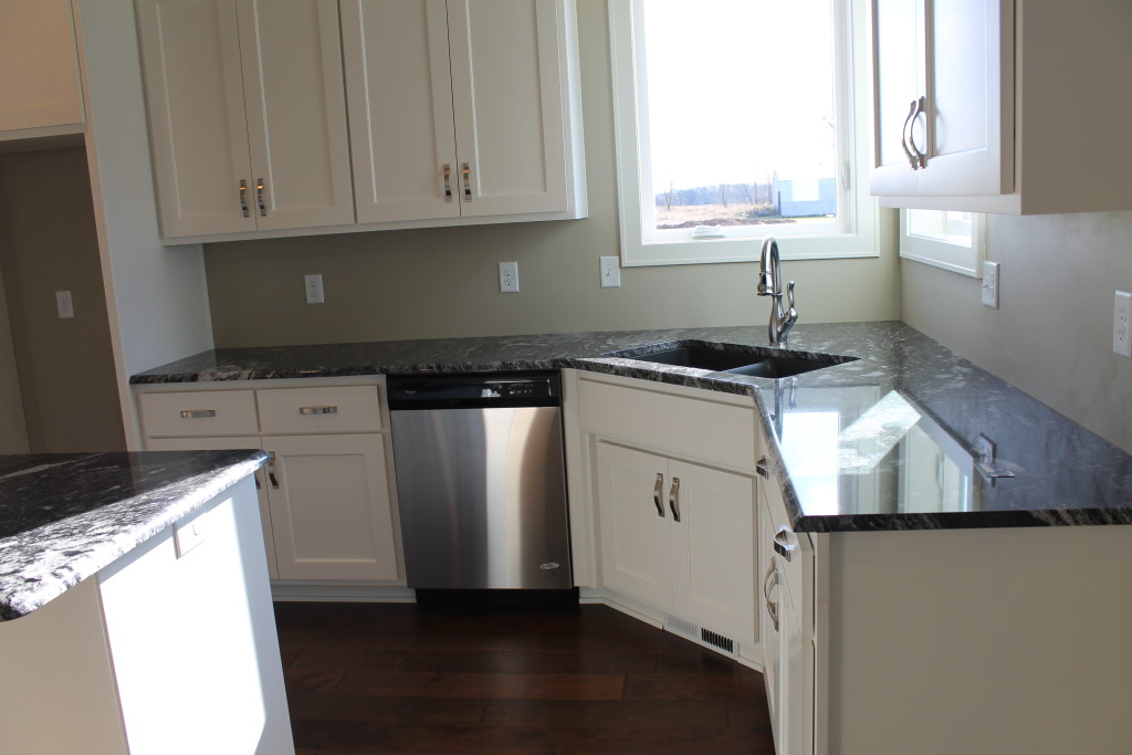 corner sink with black granite and white cabinets