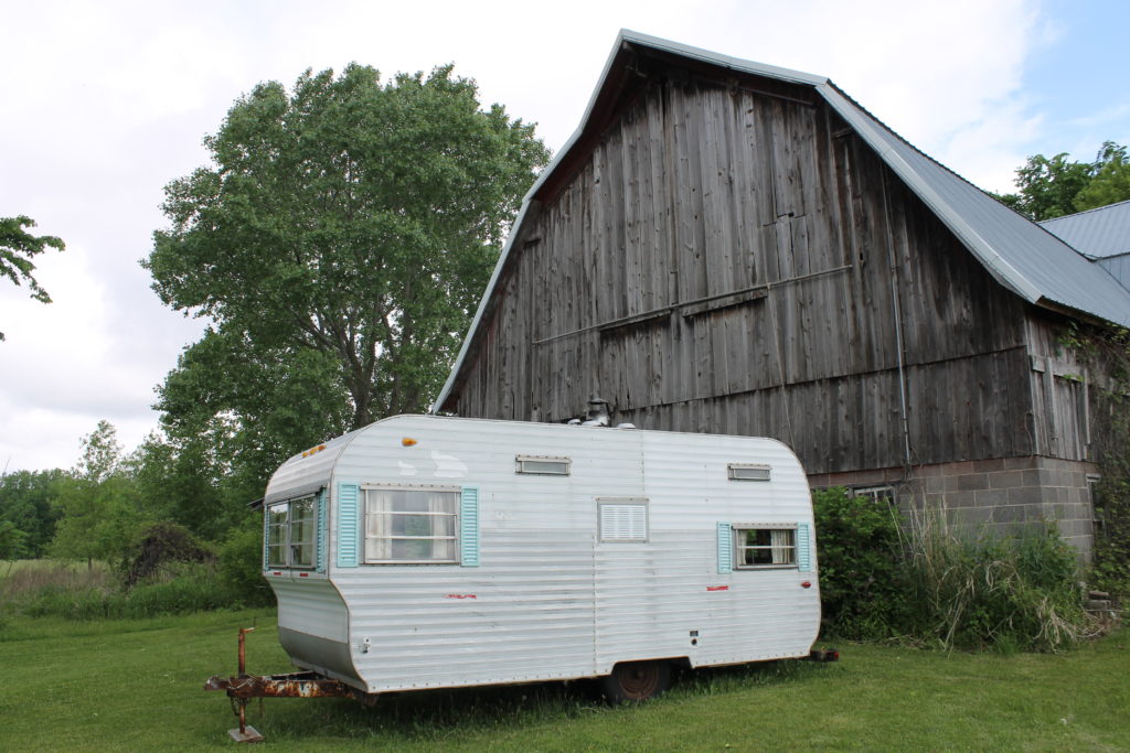 camper in front of barn