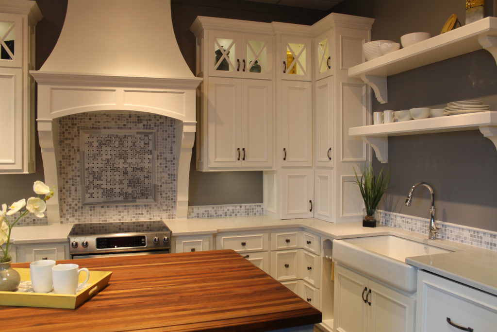 white-kitchen-with-glass-accent-cabinets-marble-backsplash-tile-and-butcher-block-top-island